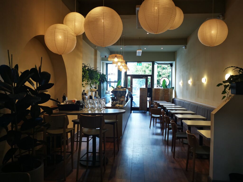 Brother Hubbard café in Ranelagh, Dublin: rattan pendant lights and paper lanterns over the terrazzo counter after the PP Construction fit-out