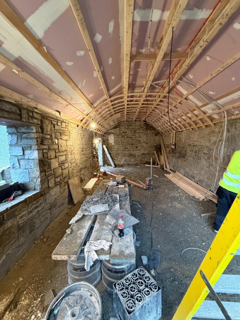 Curved timber ceiling frame and insulation being fitted inside the shed at Fagan’s pub, Moynalvey